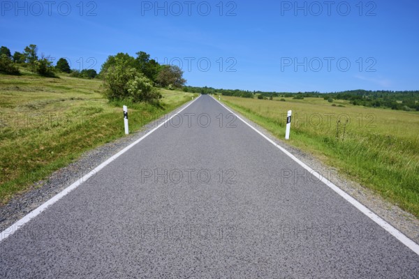 Straight country road runs through open landscape with blue sky, summer, Franzosenweg, Lange Rhön,