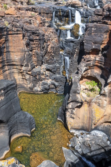Waterfall on orange-coloured rock cliffs, long exposure, Blyde River, Bourke's Luck Potholes,
