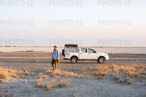 Tourist with off-road car exploring dry landscape, Kubu Island (Lekubu), Sowa Pan, Makgadikgadi