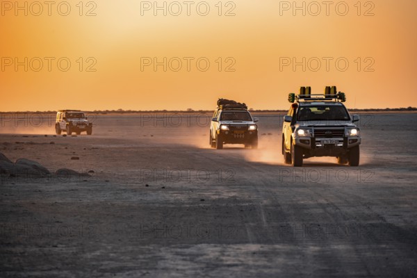Tourists explore dry landscape by off-road car, Kubu Island (Lekubu), Sowa Pan, Makgadikgadi salt