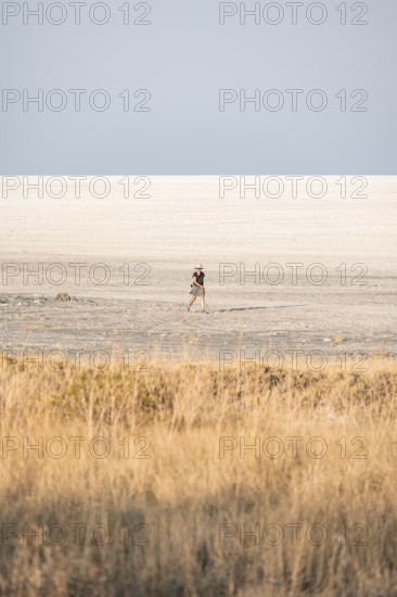 Young tourist exploring arid landscape, Kubu Island (Lekubu), Sowa Pan, Makgadikgadi salt pans,