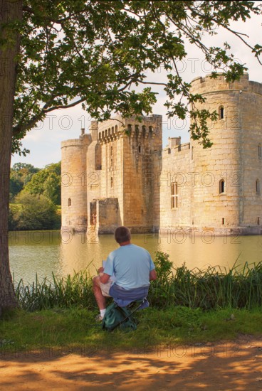 Man draws Bodiam Castle, located in East Sussex near the River Rother. It has long been one of