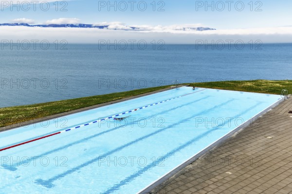 View from above of infinity pool by the sea, thermal bath, heated outdoor pool in Hofsos by
