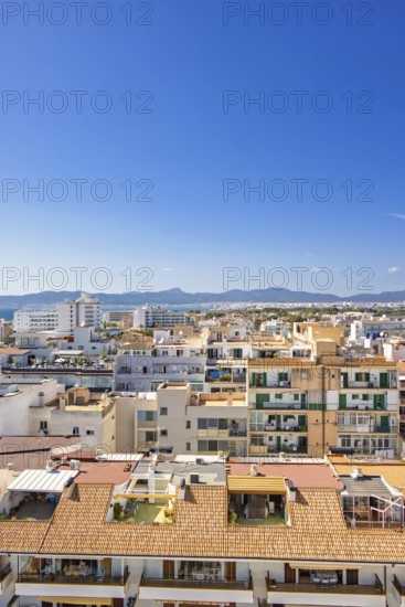 Skyline view above the house roofs in a city with tower blocks in a residental area, Can Pastilla,