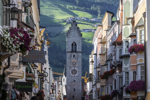 Old town, colourful houses in the main street, Zwölferturm tower at the back, Sterzing, South