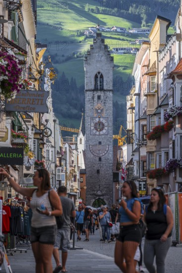 Tourists in the old town, colourful houses in the main street, Zwölferturm tower at the back,