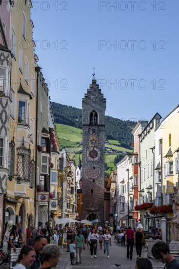 Old town, colourful houses in the main street, Zwölferturm tower at the back, old town, Sterzing,