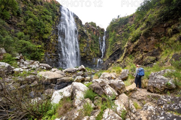 Young woman standing in front of a waterfall, Lisbon Falls, long exposure, near Graskop,
