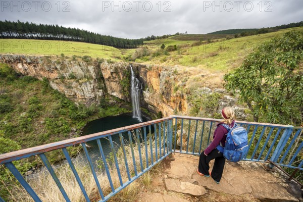 Young woman on a viewing platform, waterfall flowing into a canyon, Berlin Falls, long exposure,