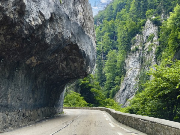 Mountain road in the Western Alps in the style of a balcony road with rock overhang above the