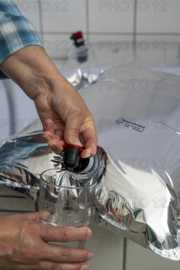 Tapping water from a 10 litre water bag, for storing drinking water at home, as an emergency