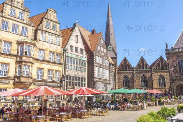 Historic row of buildings with bay windows, gabled houses, pointed tower and nave of Our Lady's
