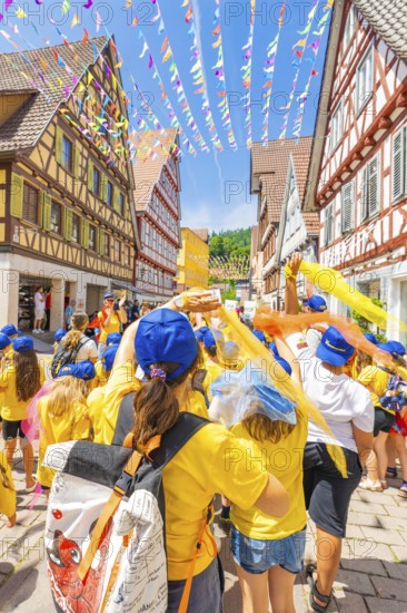 A festive group with flags in a decorated alleyway in the old town centre, 950 years of Calw, Calw