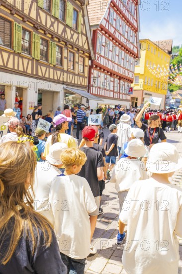 Group of children marching through a historic street during a parade, 950 years of Calw, Calw