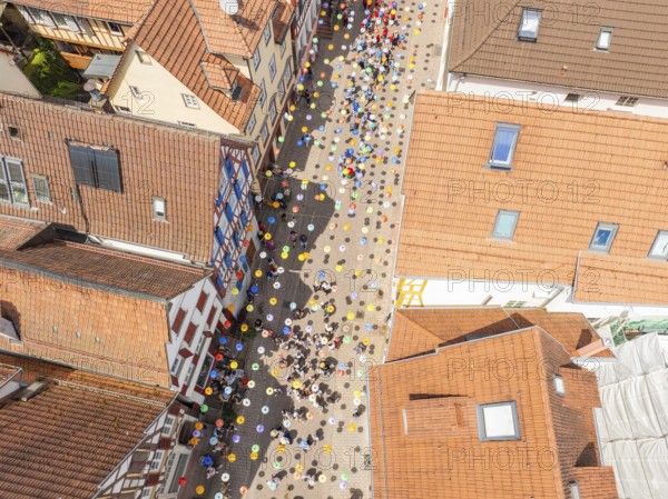 Aerial view of a busy alley with decorative colourful balloons and many people, 950 years Calw,