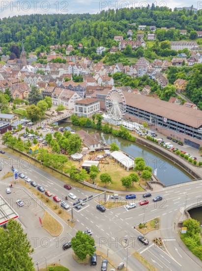 Cityscape with crossroads, cars and a large Ferris wheel along a river, 950 years of Calw, Calw