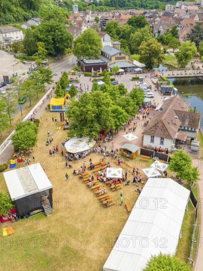Park event with many people and tents, adjacent to a river and municipal buildings, 950 years of