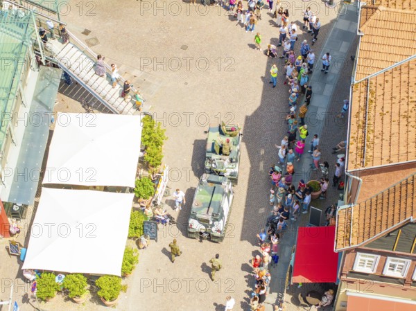 Vehicles and people on a street, lined by several buildings, 950 years Calw, parade Calw, Black