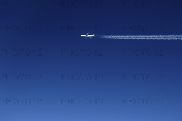 View of a passing aircraft in the blue sky at an altitude of 10, 000 metres, Atlantic flight to New