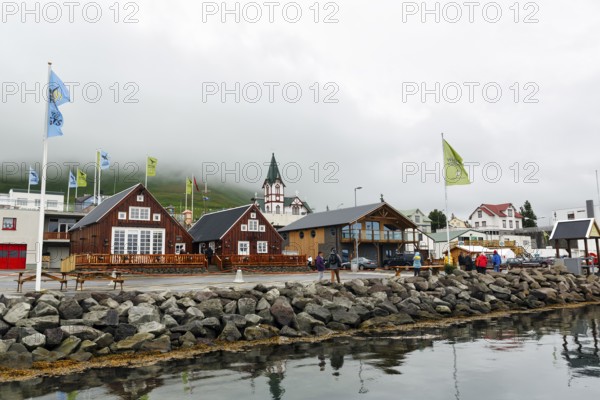 Old wooden houses with church, fishing village at Skjalfandi Bay, rain clouds, Husavik, Húsavík,