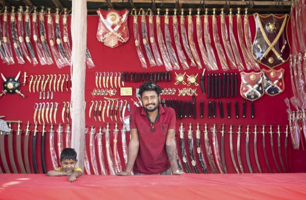 Indian man and boy at a market stall for weapons in the Thar Desert or Great Indian Desert, near