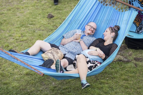 Two festival visitors lying in a hammock in the Fashion Palooza at the Lollapalooza Festival in the