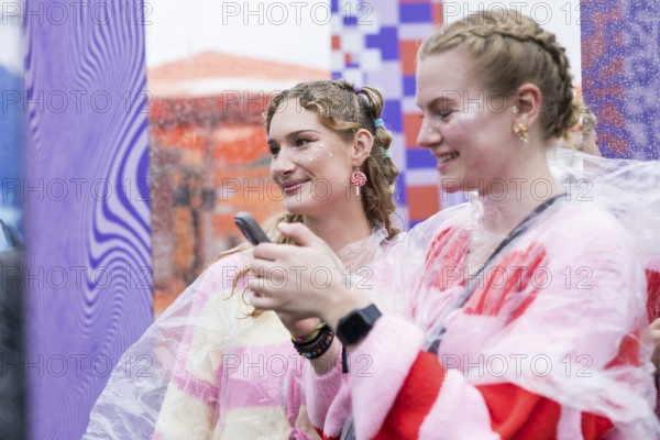 Festival visitors Emily and Celine from Halle take photos of themselves at Fashionpalooza at the