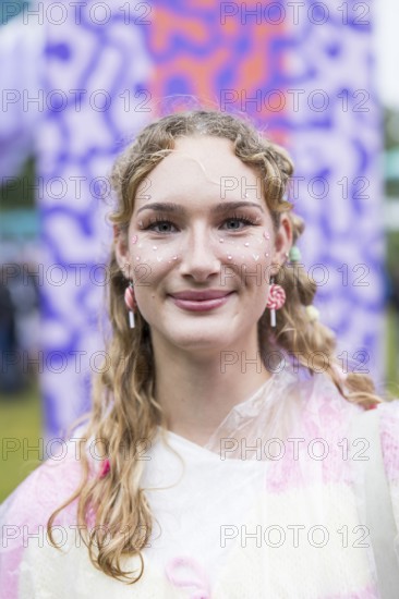 Festivalgoer Emily from Halle adorned with glitter, hearts and earrings made of candy canes at
