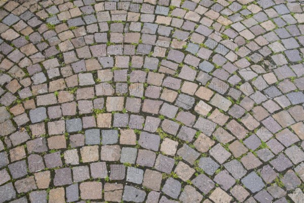 Intertwined cobblestones in an arched pattern, dominant colours are grey and pink, cobblestones,