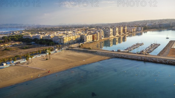 Aerial view of torrevieja coastline reflecting in mediterranean sea at sunrise, featuring acequion