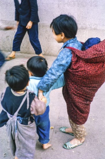 NB Poor focus. Child carrying baby looking after young children, Tai Po, New Territories, Hong