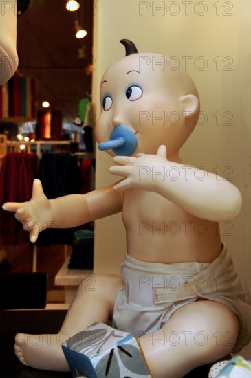 Baby mannequin with dummy in a children's shop, New York City, USA