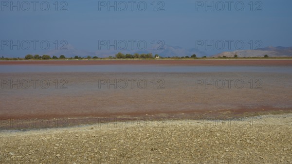 Lake with blue sky and brown shore in the distance, salt lake, Tigaki, nature reserve, hydro