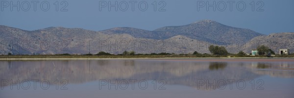 Clear mountains with a calm lake in the foreground, soft reflections and blue sky, salt lake,