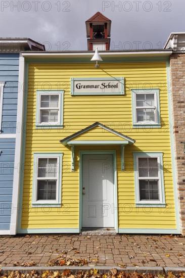 Replica, historic elementary school, yellow façade, sign, fall leaves, boutique hotel, theme hotel