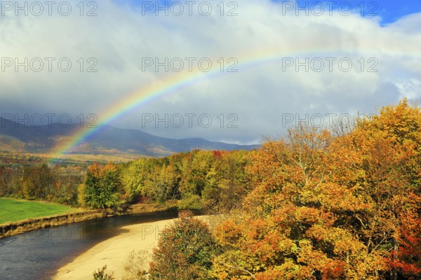 Scenic river landscape with rainbow, Saco River in Mount Washington Valley, fall leaves, Indian