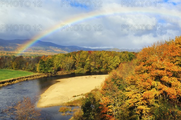 Scenic river landscape with rainbow, Saco River in Mount Washington Valley, colorful fall leaves,