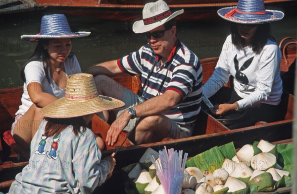 Dealer and customer in their boats at the Damnoen Saduak floating market, Thailand, December 2002,