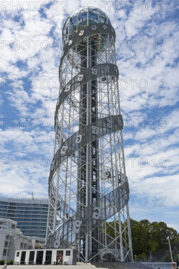 Towering tower with spiral steel structure against a cloudy sky, Alphabetic Tower, Georgian
