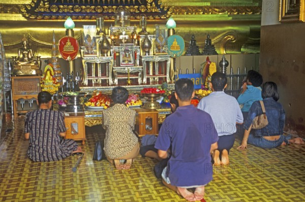 People praying in the temple with the Buddha statue Phra Mongkhonbophit, Ayutthaya, Thailand,