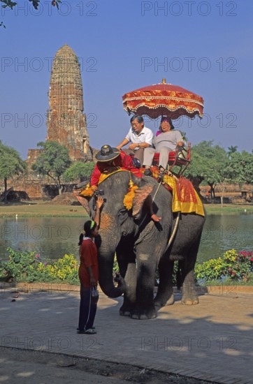 People, tourists, temple ruins, riding on an elephant through ancient sights, Ayutthaya, Thailand,