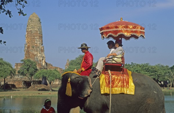 People, tourists, temple ruins, riding on an elephant through ancient sights, Ayutthaya, Thailand,