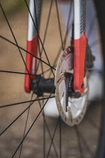 Close-up of a bicycle part with red and silver design showing the mechanics and brake disc,