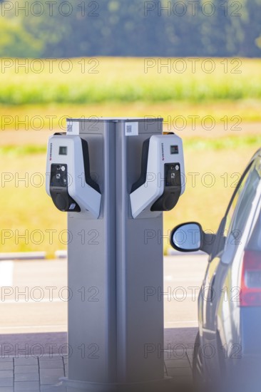 Electric car at a double charging station in a parking lot with a view of nature, e-charging park,