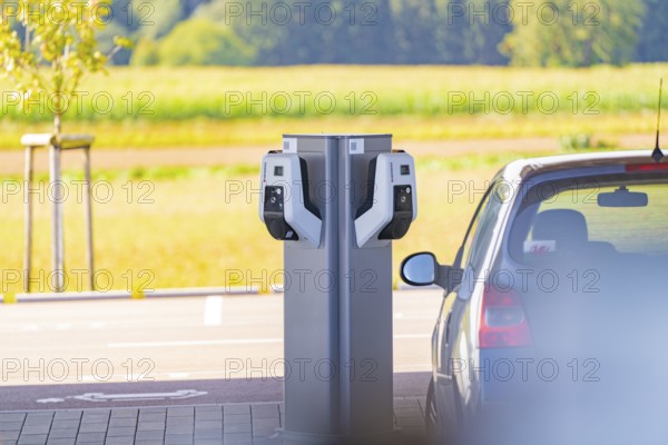 Electric vehicle at a charging station with a view of a natural landscape, e-charging park,