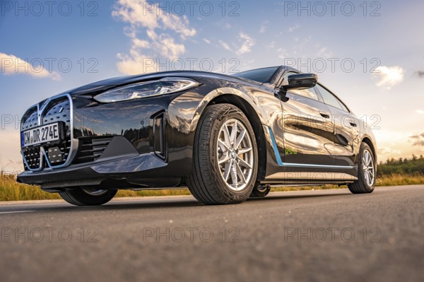 Black car on the road from a frog's eye view with blue sky, BMW i7 electric car, Deer e-Carsharing,