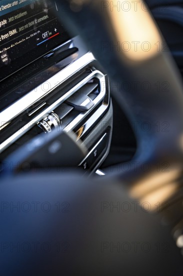 Close-up of a modern car interior with focus on steering wheel and dashboard, BMW i7 electric car,