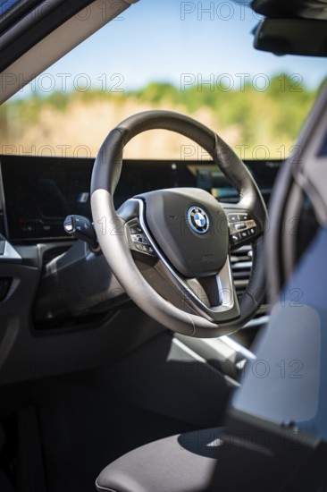 View of the modern steering wheel and display in the interior of a car, BMW i7 electric car, Deer