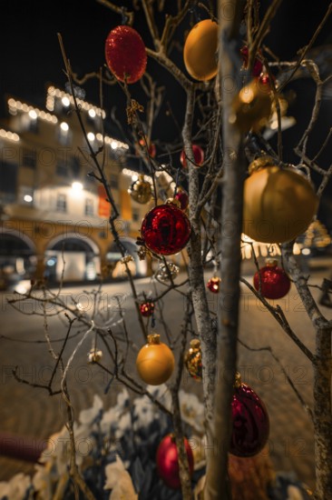 Christmassy decorated tree with balls and lights in a nighttime street scene, Calw, Black Forest,