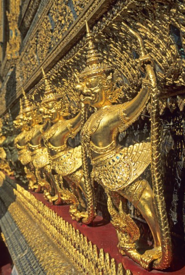 Golden mythical creatures, statues, Garudas, at Wat Phra Kaeo, Bangkok, Thailand, December 2002,
